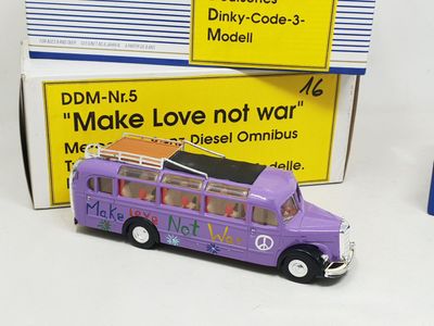 un petit bus jouet violet posé à côté d'une boîte
