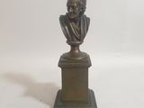 buste en bronze d'un homme sur un socle, sur fond blanc