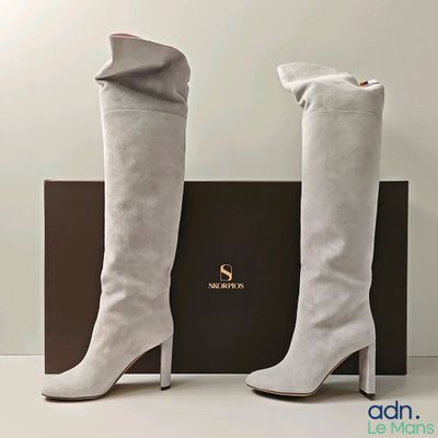 La femme porte une paire de bottes blanches à bout carré.