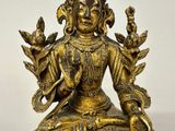 a gold statue of a woman sitting in a lotus position