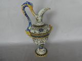 a blue and white vase with a handle on a table