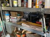 a shelf full of paint and other items in a garage