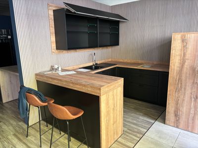 a kitchen with a wooden counter top and black cabinets