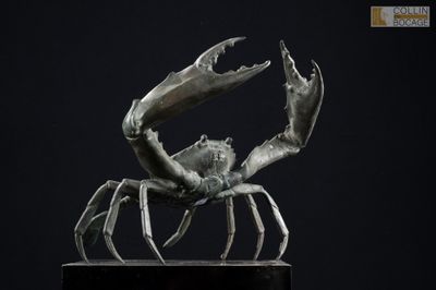 une image représentant une sculpture de crabe sur une surface noire