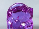 a purple glass figurine of a cat sitting on a table