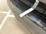 a sticker on the bumper of a car that is parked in a parking lot