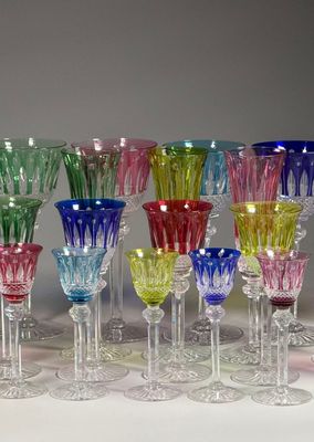 many different colored wine glasses in a row on the table