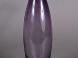 un vase en verre violet posé sur une table
