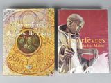 two books on a table with a picture of a man in a priest ' s robe and a picture of a man in a priest ' s robe