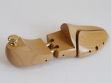 a wooden shoe that is sitting on a white surface