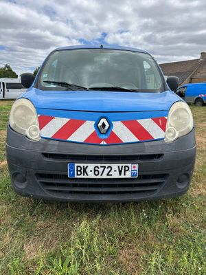 une camionnette bleue avec une bande rouge et blanche garée dans un champ