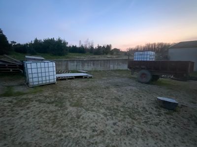 un camion garé sur un terrain en terre battue près d'une clôture