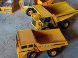 trois camions miniatures posés les uns à côté des autres sur le sol