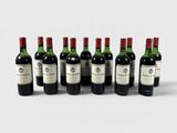 six bouteilles de vin sont alignées sur une surface blanche