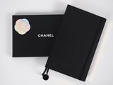 a black notebook with a sticker on it next to a black box