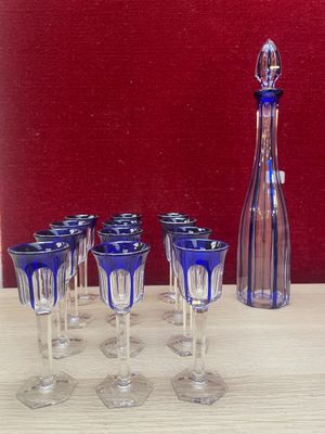 six wine glasses and a decanter sitting on a table