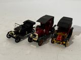 three toy cars sitting side by side on a white surface