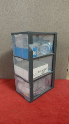 a picture of a three tiered storage unit with plastic bins