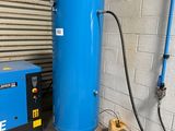 a blue compressor and a blue tank in a garage