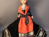 an image of a doll of a woman in a black and orange dress