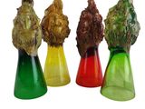 quatre vases en verre de couleurs différentes, surmontés d'une tête de lion