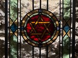 a close up of a stained glass window with a star of david on it