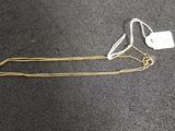 a close up of a gold chain with a tag attached to it