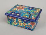 une petite boîte bleue ornée d'un motif floral
