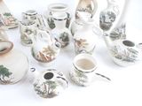 many pieces of pottery that are sitting on a table