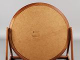 an image of a wooden plate on a stand on a gray surface