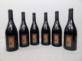 six bouteilles de vin sont alignées sur une table