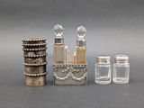 three bottles and two salt shakers sitting next to each other