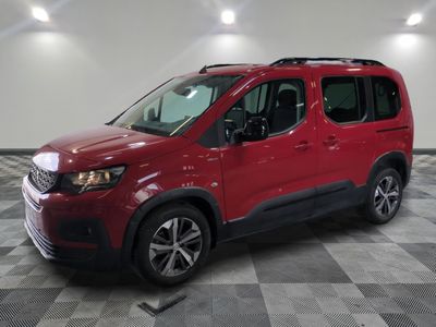La camionnette rouge est garée sur un sol en damier dans un garage.