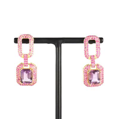 une paire de boucles d'oreilles ornées de pierres roses et de cristaux roses