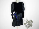 mannequin vêtu d'une robe noire ornée d'un ruban bleu et d'un chapeau