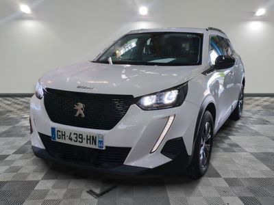 la voiture blanche est garée sur un sol en damier dans le garage