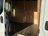 une camionnette blanche dont la porte est ouverte, garée sur un parking