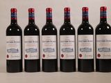 six bouteilles de vin sont alignées sur une table