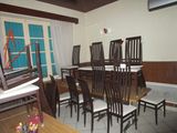 tables and chairs in a room with a large window and a blue door