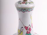 a white vase with colorful designs on it on a table