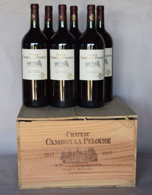 four bottles of red wine in a wooden crate on a table