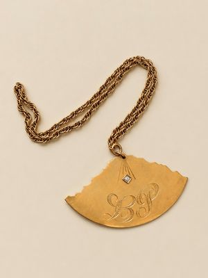 Gros plan sur un collier en or orné d'un oiseau