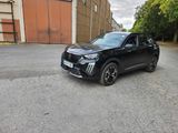 a black suv parked in a parking lot next to a building