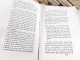 an open book sitting on top of a table next to a pile of books