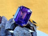 an image of a purple stone ring sitting on top of a rock