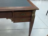 a small desk with a black top in a room