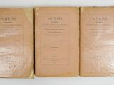 trois vieux livres empilés les uns sur les autres sur une table