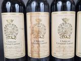 four bottles of wine are lined up on a table