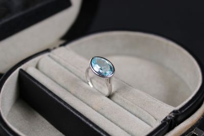 a ring in a case with a blue topaz stone