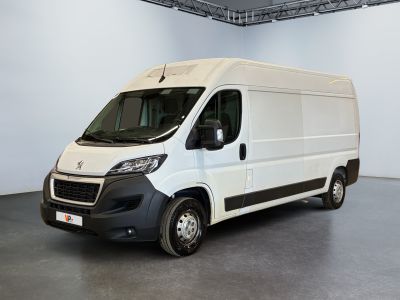 La camionnette blanche est garée dans la grande salle du bâtiment.